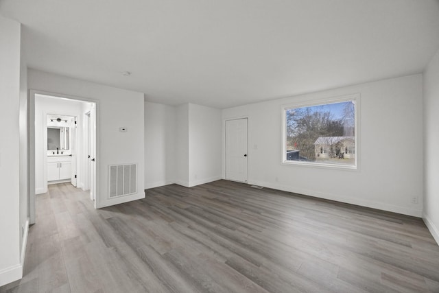 spare room featuring visible vents, baseboards, and wood finished floors