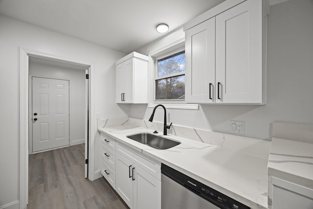 kitchen featuring dishwasher, light stone counters, wood finished floors, white cabinetry, and a sink