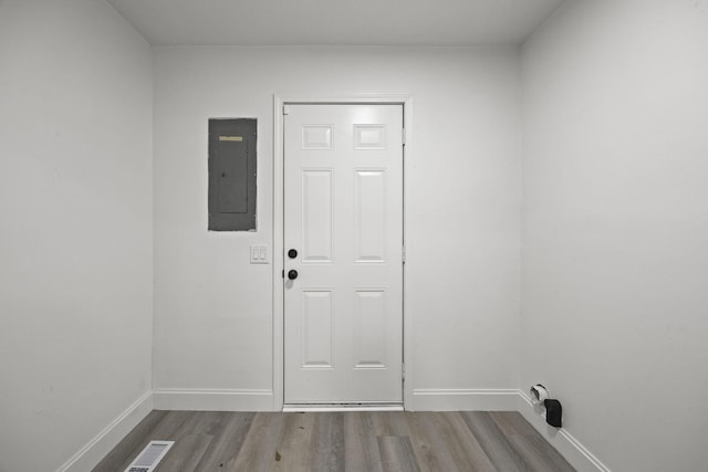 laundry area with laundry area, wood finished floors, visible vents, baseboards, and electric panel