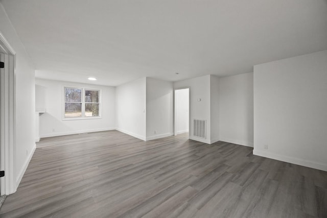 spare room featuring visible vents, baseboards, and wood finished floors