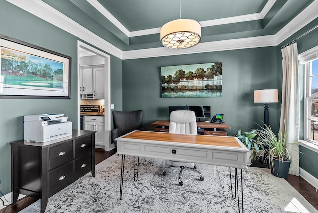 office area featuring ornamental molding, wood finished floors, a raised ceiling, and baseboards