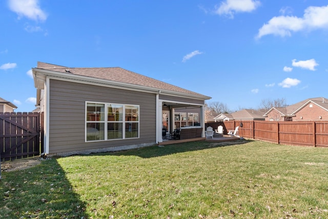 rear view of house with a patio area, a fenced backyard, roof with shingles, and a yard