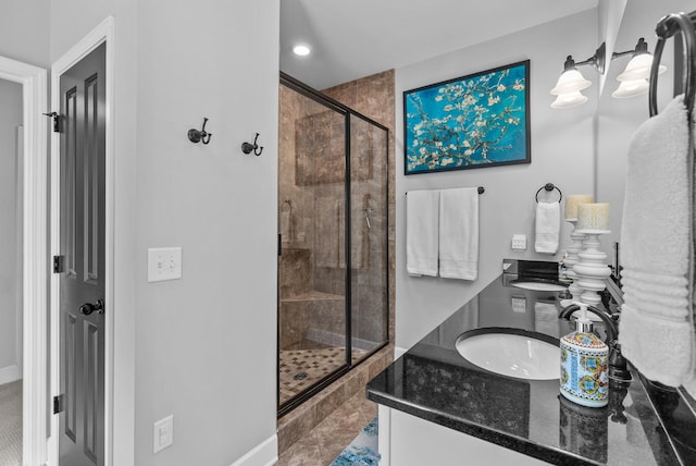 full bath featuring a sink, a shower stall, and double vanity