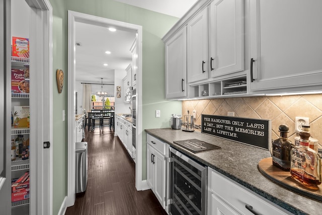 kitchen featuring a chandelier, beverage cooler, white cabinets, backsplash, and dark wood finished floors