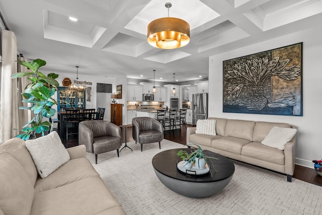 living room with a chandelier, beam ceiling, coffered ceiling, and wood finished floors