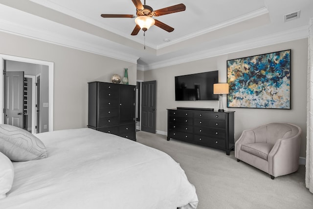 bedroom featuring visible vents, a tray ceiling, ornamental molding, and light colored carpet