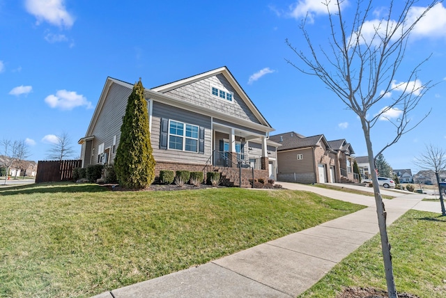 view of front facade featuring driveway, brick siding, a front lawn, and a porch