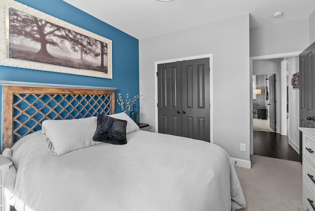 carpeted bedroom with a closet and baseboards