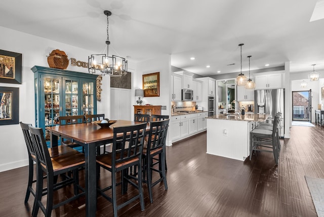 dining area with dark wood-style floors, baseboards, a chandelier, and recessed lighting