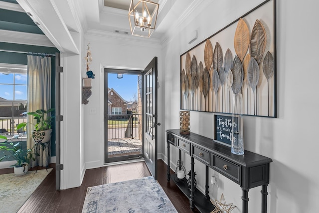 foyer with a notable chandelier, visible vents, baseboards, ornamental molding, and dark wood-style floors