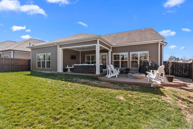 back of property with a patio, a fenced backyard, a yard, roof with shingles, and an outdoor living space with a fire pit