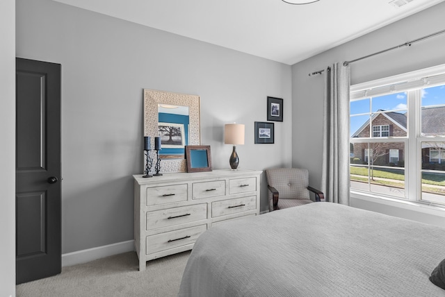 bedroom with visible vents, multiple windows, light carpet, and baseboards