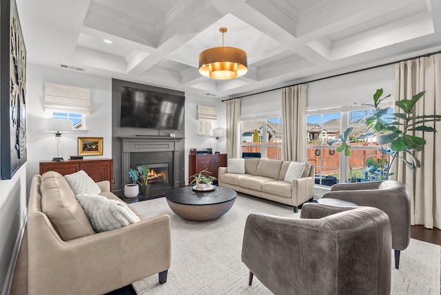 living room featuring a warm lit fireplace, visible vents, plenty of natural light, and beamed ceiling