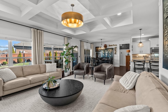 living area featuring crown molding, coffered ceiling, beamed ceiling, and an inviting chandelier