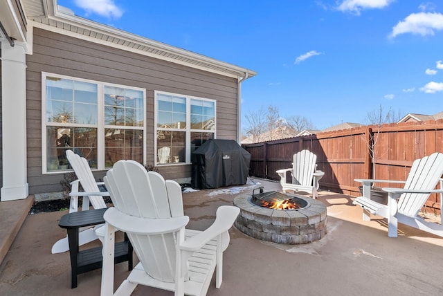 view of patio with an outdoor fire pit, a grill, and fence