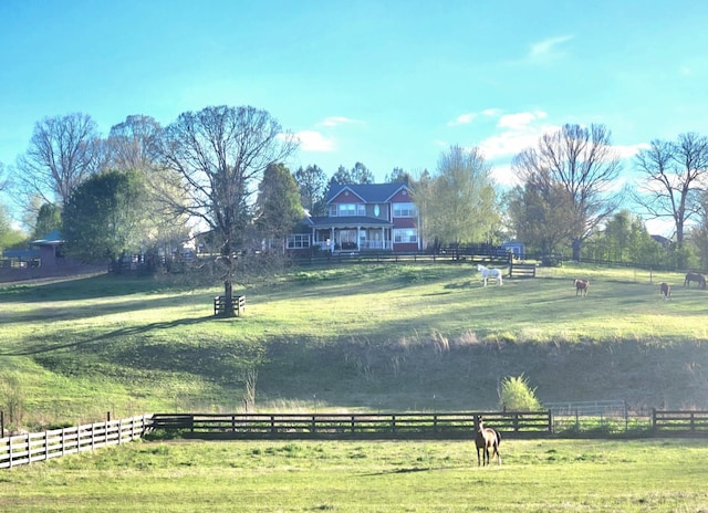 view of yard with fence and a rural view