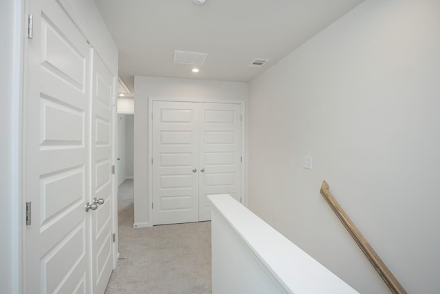 hallway with light carpet, recessed lighting, visible vents, and an upstairs landing