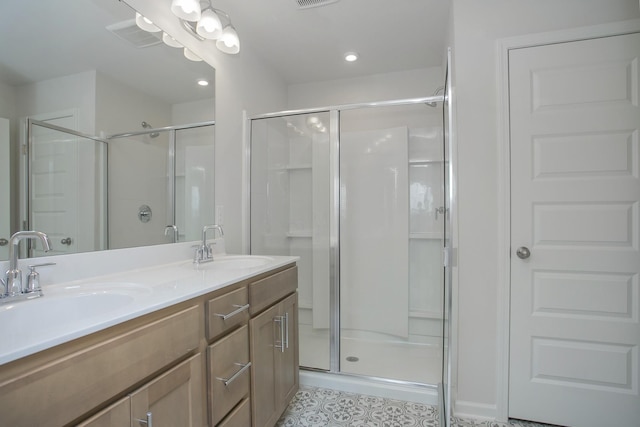 full bathroom with double vanity, a stall shower, and a sink