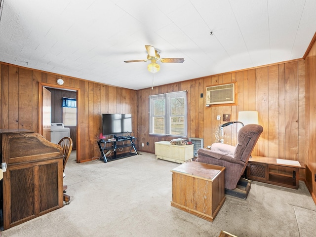 carpeted living area featuring washer / dryer, wooden walls, a ceiling fan, and a wall mounted AC