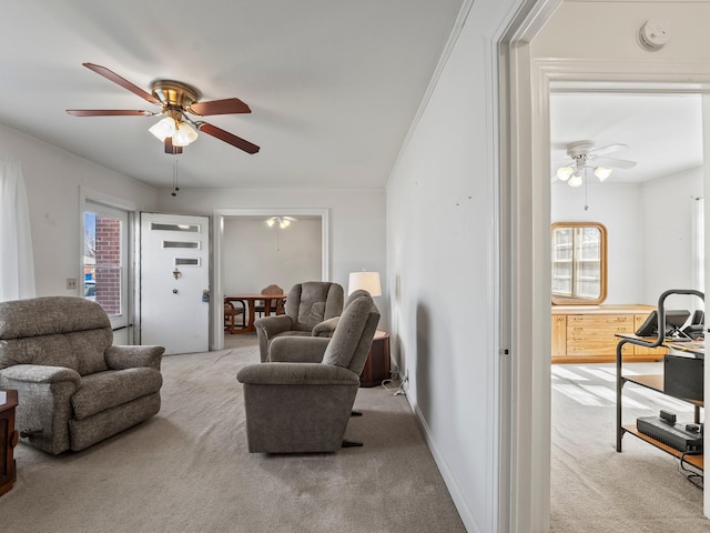 carpeted living area featuring ceiling fan and baseboards