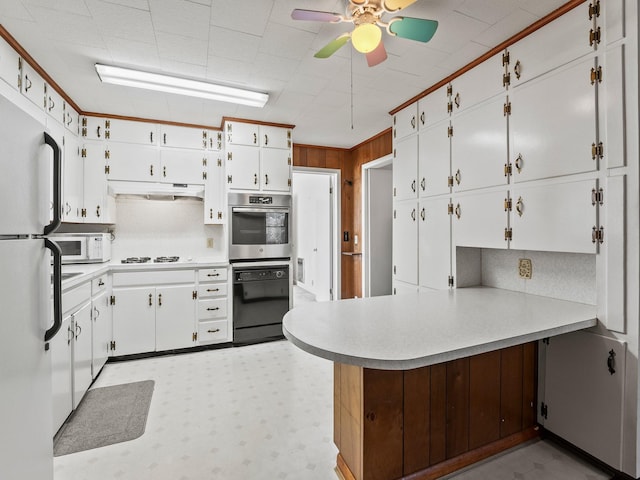 kitchen featuring light floors, white appliances, a peninsula, and white cabinetry