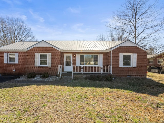 ranch-style house featuring crawl space, a front lawn, metal roof, and brick siding