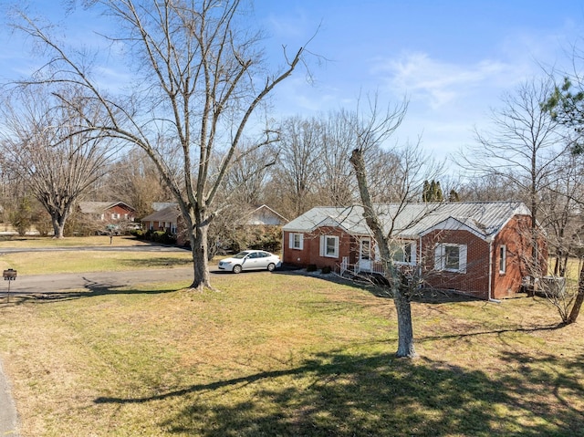 view of front of house with a front yard and brick siding