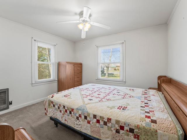 bedroom with carpet floors, heating unit, multiple windows, and crown molding