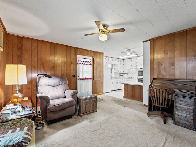 living room featuring light carpet, ceiling fan, ornamental molding, and wooden walls