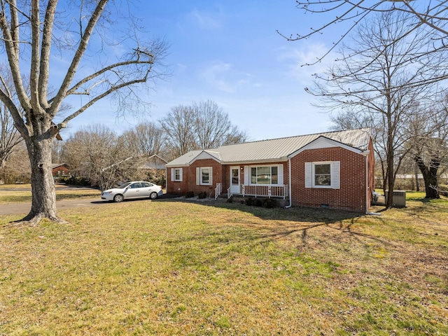 view of front facade featuring crawl space, a front yard, metal roof, and brick siding