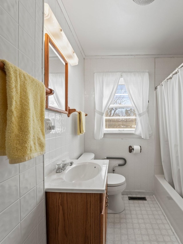 bathroom with visible vents, tile walls, toilet, and vanity