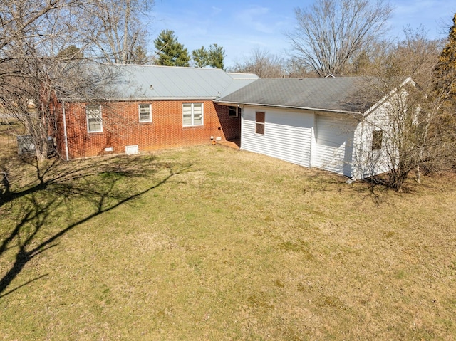 exterior space featuring a yard and brick siding