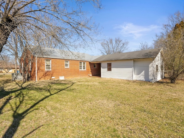 rear view of house featuring brick siding and a lawn