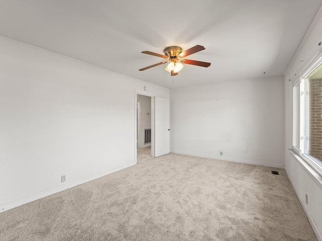 empty room with light carpet, ceiling fan, and visible vents