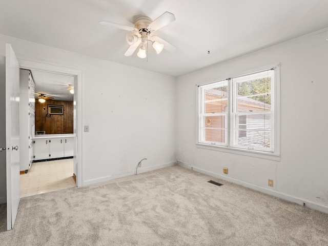 unfurnished bedroom featuring carpet flooring, visible vents, baseboards, and a ceiling fan