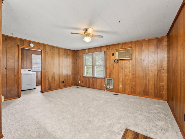 spare room with a ceiling fan, carpet flooring, washer / dryer, a wall mounted air conditioner, and heating unit