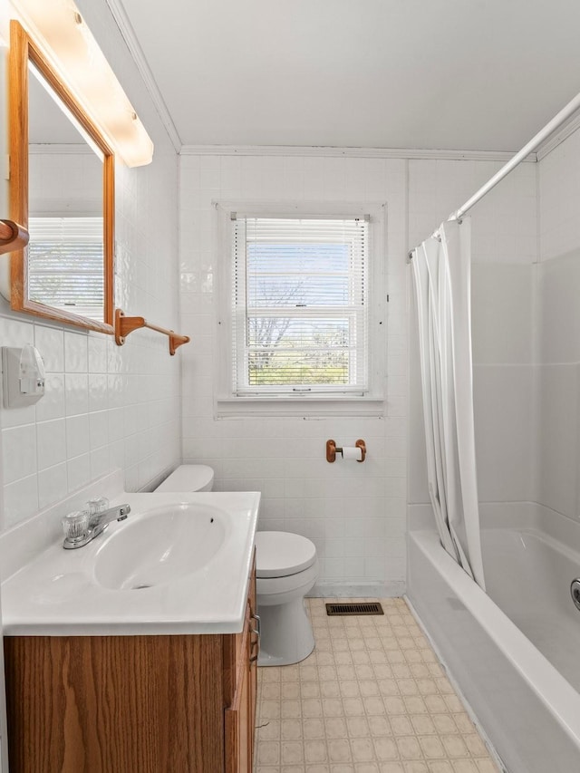 bathroom featuring visible vents, toilet, vanity, and tile walls