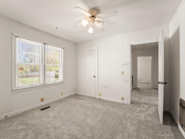 unfurnished bedroom with ceiling fan, visible vents, attic access, carpet flooring, and baseboards