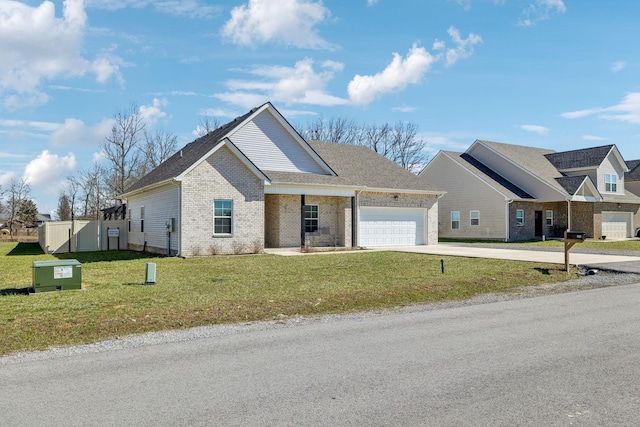 view of front of house featuring a garage, driveway, a front yard, and brick siding