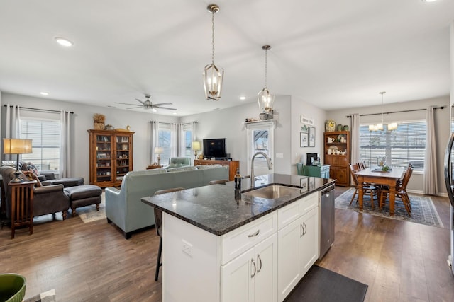 kitchen featuring open floor plan, stainless steel dishwasher, dark wood-style flooring, and a sink