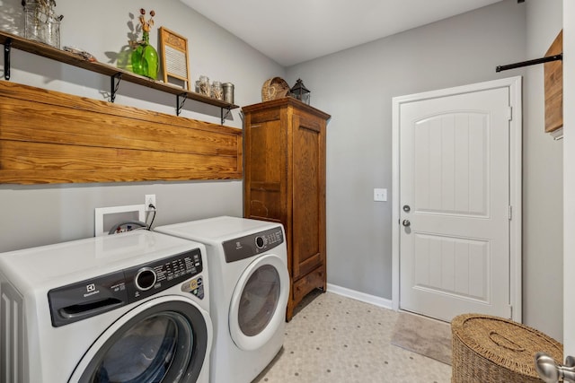 laundry area with baseboards, cabinet space, light floors, and separate washer and dryer