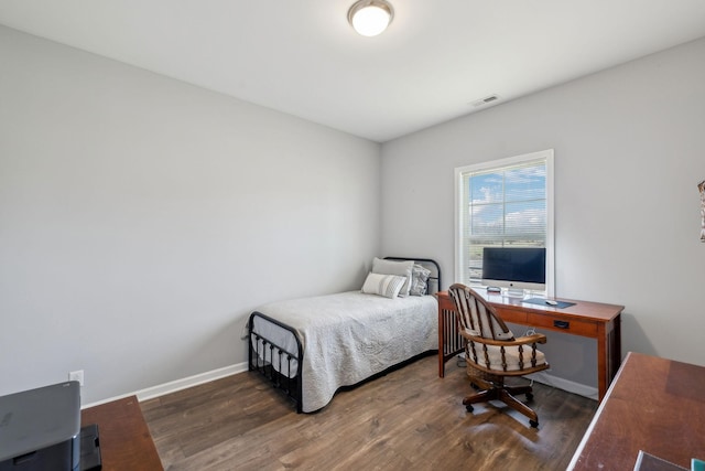 bedroom featuring visible vents, baseboards, and wood finished floors