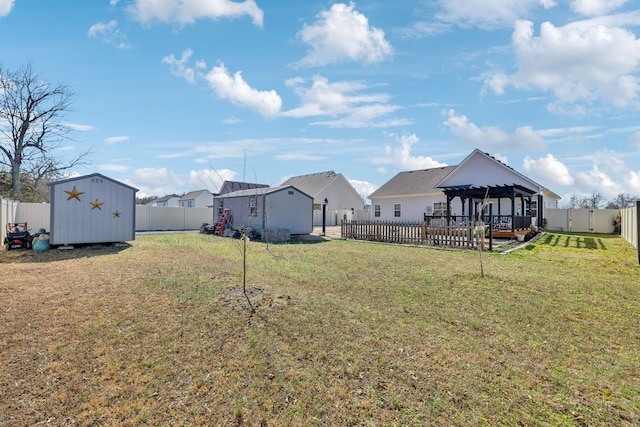 view of yard with a fenced backyard, a residential view, a storage unit, and a gazebo