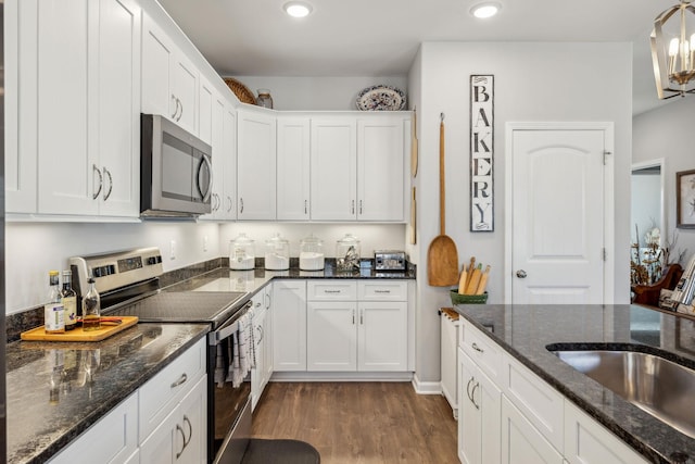 kitchen with dark wood finished floors, stainless steel appliances, recessed lighting, white cabinetry, and a sink