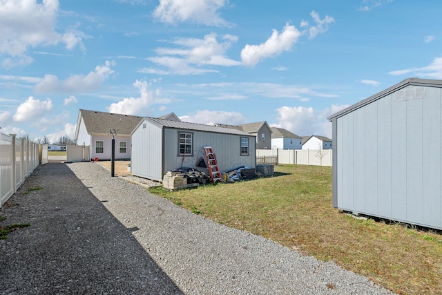 view of shed with gravel driveway and a fenced backyard