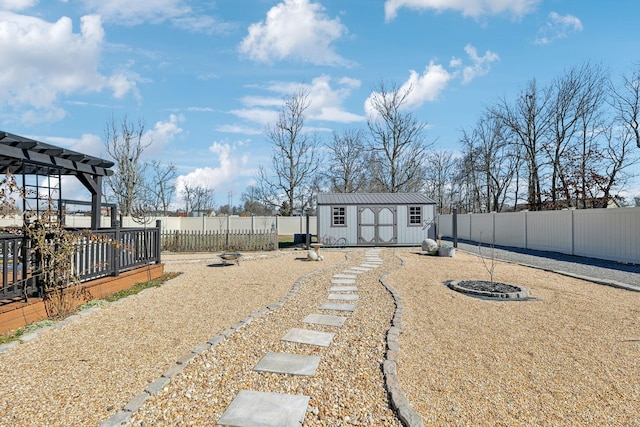 view of yard featuring a shed, an outdoor structure, a fenced backyard, and a pergola