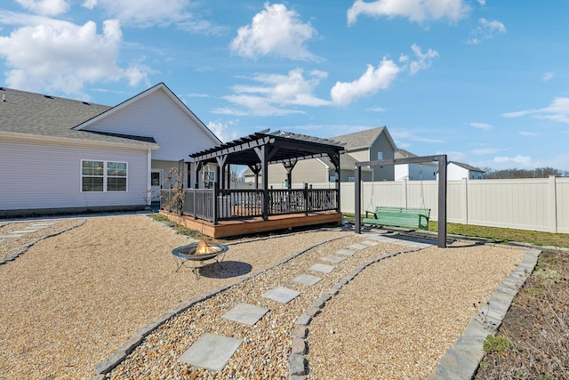 view of patio with fence, a fire pit, a wooden deck, and a pergola