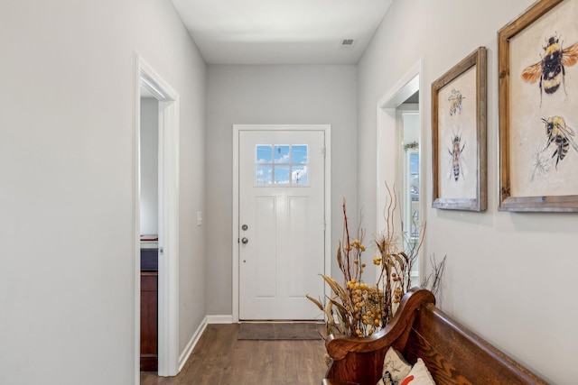 foyer featuring wood finished floors, visible vents, and baseboards