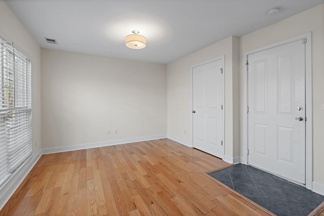 unfurnished bedroom with light wood-type flooring, visible vents, and baseboards