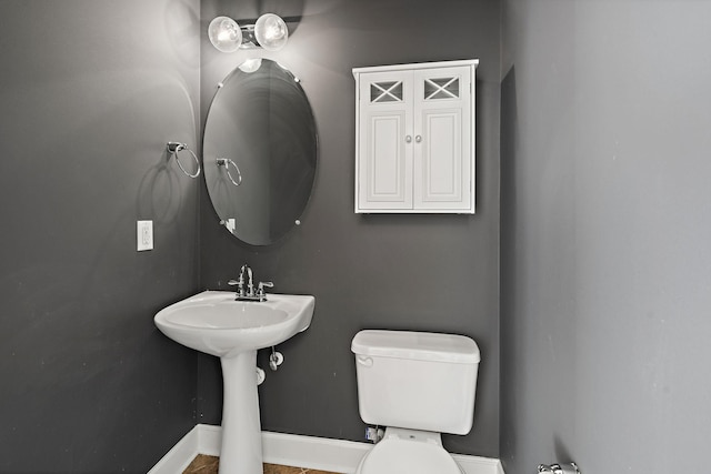 bathroom with toilet and baseboards